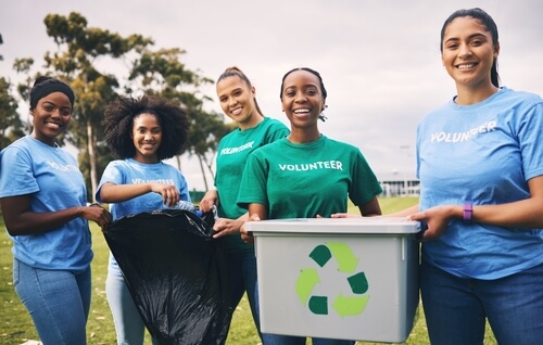 5 students wearing volunteering shirts and holding recycling boxes - student volunteering uk